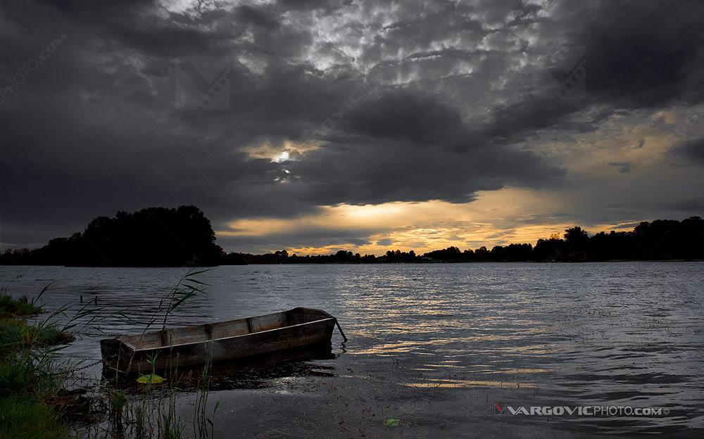 Abandoned fihishing boat on the Croatian Soderica lake on the front of winter sunset by photographer Boris Vargovic